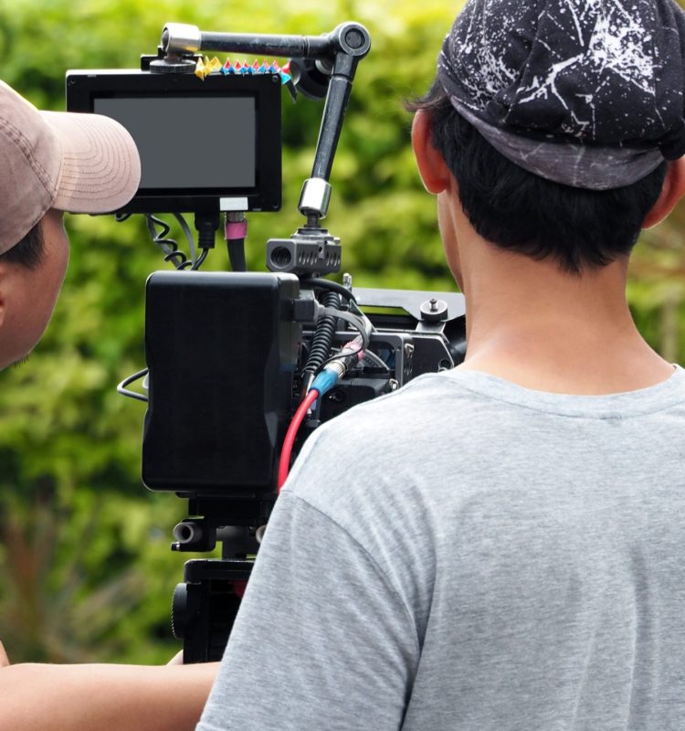 Behind the scenes of vdo production or video shooting at outdoor location with film crew camera team and movie director.